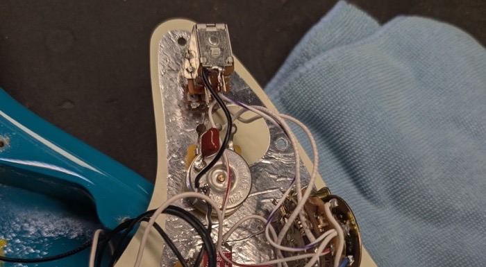 Shielded Stratocaster pickguard with pots, capacitor, and five-way switch wired